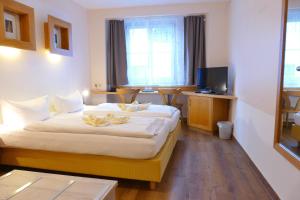 a hotel room with a bed and a television at Altstadt-Hotel Zum Hechten in Füssen