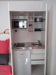 a small kitchen with a sink and a microwave at Gasthaus Löwen in Unterreichenbach