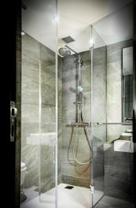 a shower with a glass door in a bathroom at Rodas An Ecotel Hotel in Mumbai