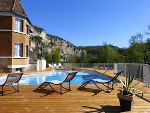 una terraza con 2 sillas y una piscina en Hôtel Restaurant des Grottes du Pech Merle, en Cabrerets