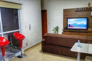 a living room with a couch and a flat screen tv at FRODO-APTO MAGNÍFICO com Wifi , 2 dorm in São Carlos