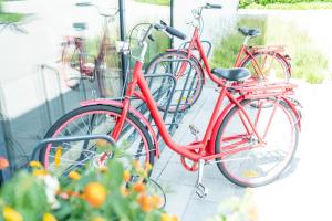 two red bikes are parked next to each other at Bader Hotel in Parsdorf