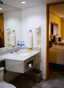 baño con lavabo, espejo y cama en Samba Vallarta All Inclusive, en Nuevo Vallarta 