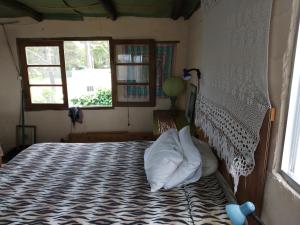 a bedroom with a bed with a white comforter and a window at Para pasar bien! in Maldonado