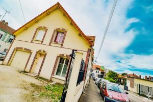 a yellow house with cars parked in front of it at DUPLEX CENTRE VILLE 6 personnes (WIFI/PARKING) in Troyes +2 photos