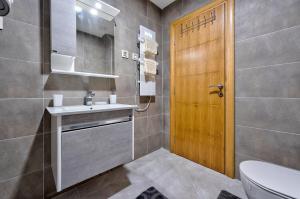 een badkamer met een toilet, een wastafel en een houten deur bij Santos Hills Zlatibor in Zlatibor +28 foto's