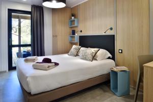 a bedroom with a large bed with white sheets at Résidence & Hotel U Livanti ECOLABEL in Propriano