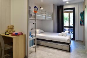 a small bedroom with a bunk bed and a desk at Résidence & Hotel U Livanti ECOLABEL in Propriano