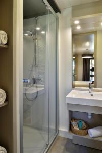 a bathroom with a glass shower and a sink at Résidence & Hotel U Livanti ECOLABEL in Propriano