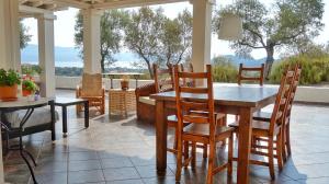 a porch with a table and chairs on a patio at Olive Bay Hilltop Apartments Ammouliani in Ammouliani