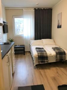 um pequeno quarto com uma cama e uma janela em Kristiansund Apartments em Kristiansund