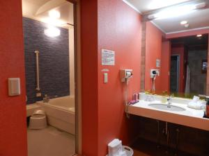 a bathroom with a sink and a tub and a toilet at Hotel Mariage (Adults only) in Tsukuba