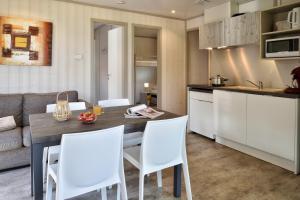 a kitchen and living room with a table and chairs at Résidence & Hotel U Livanti ECOLABEL in Propriano