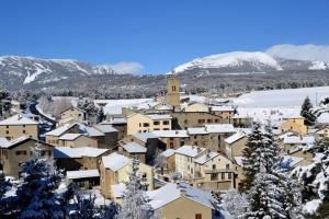 a town covered in snow with mountains in the background at Maison de village spacieuse au calme in Matemale