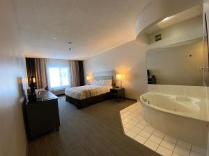 a hotel room with a bed and a bath tub at Country Inn & Suites by Radisson, Elk River, MN in Elk River