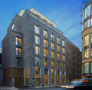 um edifício de tijolos com muitas janelas numa rua em The Guardsman - Preferred Hotels and Resorts em Londres