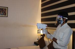 un uomo ha un asciugacapelli in mano in una stanza di Hotel Jukaso Inn Down Town a Nuova Delhi