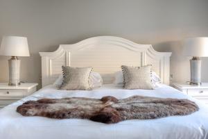 a large fur blanket on a bed with two lamps at Woolmarket House in Chipping Campden