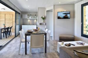 a kitchen and living room with a table and chairs at Résidence & Hotel U Livanti ECOLABEL in Propriano