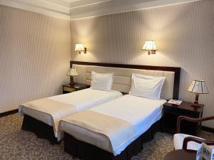 a hotel room with two beds and two lamps at Sofievsky Posad Hotel in Kyiv