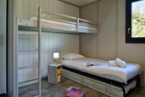 a bedroom with two bunk beds and a lamp at Résidence & Hotel U Livanti ECOLABEL in Propriano
