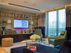 uma sala de estar com duas cadeiras e uma televisão em The Guardsman - Preferred Hotels and Resorts em Londres