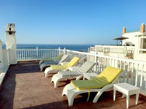 eine Reihe von Liegestühlen auf einem Balkon mit Meerblick in der Unterkunft Jack's Apartments & Suites in Essaouira