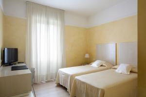 um quarto de hotel com duas camas e uma televisão em Hotel Colombia em Milão