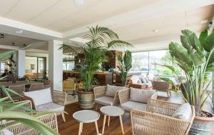 a living room with chairs and tables and plants at Hotel Maritim in Roses
