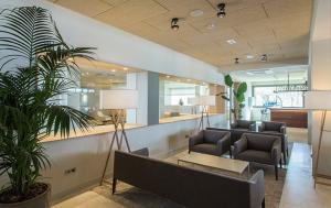 a lobby with couches and a table and a plant at Hotel Maritim in Roses