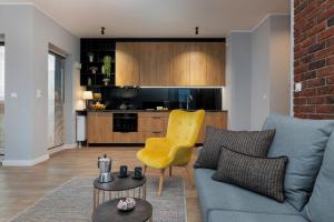 un salon avec un canapé bleu et un fauteuil jaune dans l'établissement Exclusive Apartments Mostowa by Renters Prestige, à Poznań