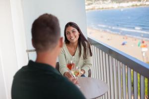 a man and a woman sitting at a table with wine glasses at Hotel Maritim in Roses