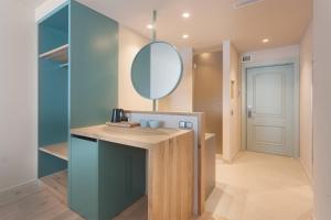 a bathroom with a vanity with a mirror and a door at Hotel Maritim in Roses