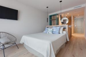 a bedroom with a bed and a chair and a television at Hotel Maritim in Roses