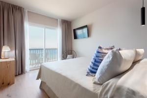 a hotel room with a bed and a balcony at Hotel Maritim in Roses