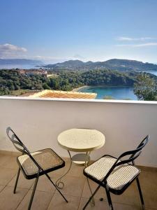 a table and chairs on a balcony with a view at Olive Bay Hilltop Apartments Ammouliani in Ammouliani