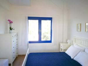 a bedroom with a blue bed and a window at Olive Bay Hilltop Apartments Ammouliani in Ammouliani