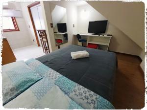 1 dormitorio con 1 cama y escritorio con TV en Residencial João Pessoa, en Canela