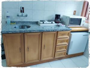 a kitchen with a sink and a counter top at Residencial João Pessoa in Canela