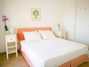a bedroom with a bed with two night stands and two tables at Olive Bay Hilltop Apartments Ammouliani in Ammouliani
