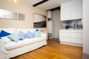 sala de estar con sofá blanco y almohadas azules en Turistiqa - Ferrol - Triplex Centro, en Ferrol