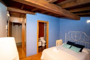 Dormitorio azul con cama y aseo en Turistiqa - Ferrol - Triplex Centro, en Ferrol