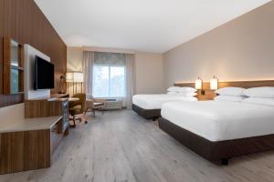 a hotel room with two beds and a flat screen tv at Wyndham Garden Orlando Universal / I Drive in Orlando +26 photos