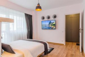 Un dormitorio blanco con una cama y una ventana. en Timpuri Noi - Studio 54 by MRG Apartments, en Bucarest