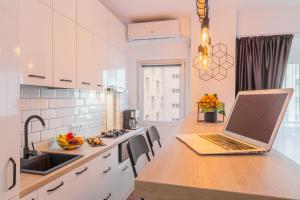 ordenador portátil con encimera de madera en la cocina en Timpuri Noi - Studio 54 by MRG Apartments, en Bucarest 9 fotos más