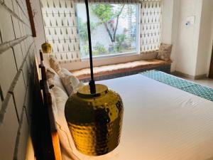 un jarrón sentado en una cama junto a una ventana en The Bougainvillea Bed & Breakfast, en Amritsar