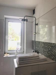 a bathroom with a window and a sink with towels at Martins Guesthouse Zimmer in Hannover