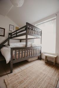 a bedroom with a wooden bunk bed and a window at Unique, cosy, Lake District artist hideaway - 5 bd in Millom