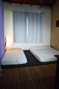 2 camas en una habitación con ventana en Mozamba Surf House, en Florianópolis