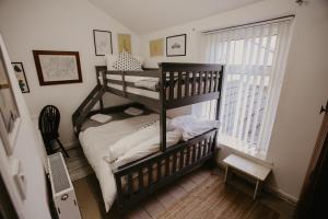a bedroom with a bunk bed and a window at Unique, cosy, Lake District artist hideaway - 5 bd in Millom